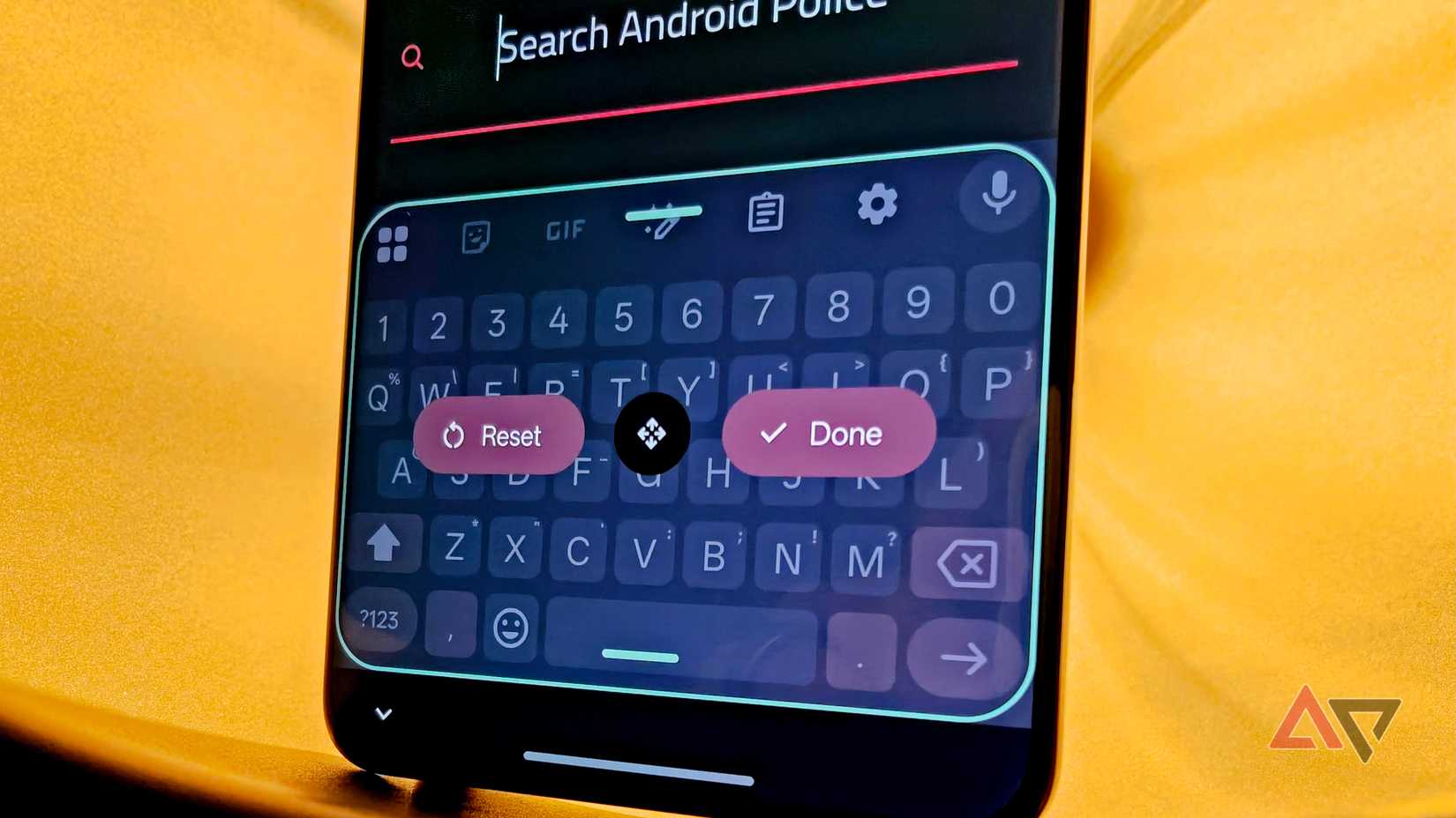 OnePlus 13 in a lamp with a warm light behind it showing the Gboard resize and reposition options