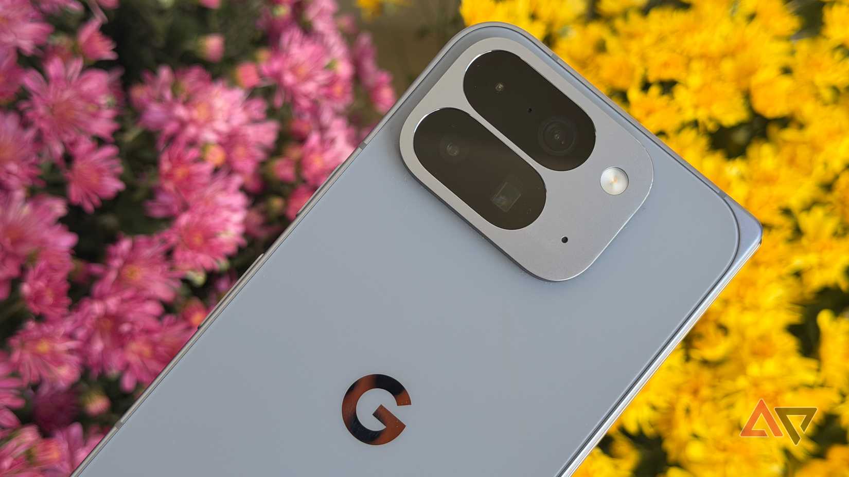 Google Pixel 10 Pro Fold held up against purple and yellow mums