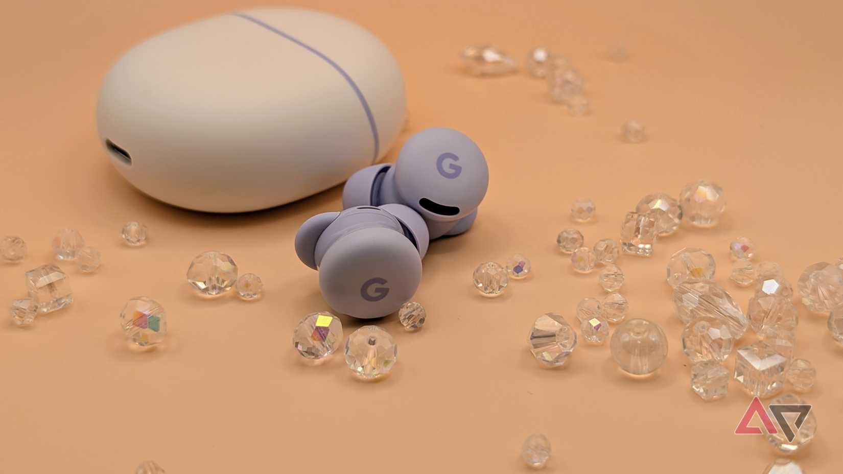 Google Pixel Buds 2a with case surrounded by glass beads