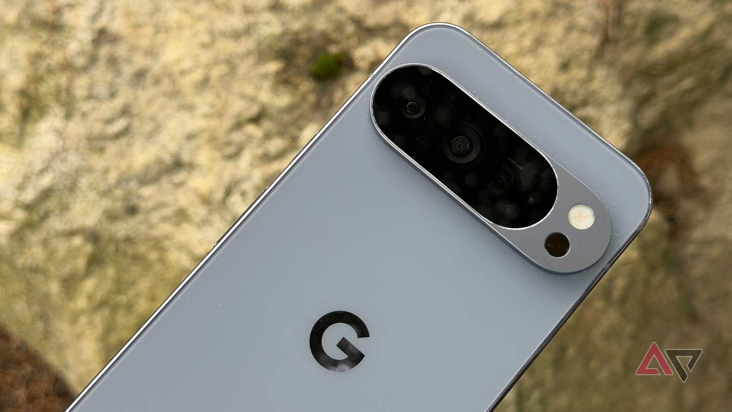 Google Pixel 10 Pro XL held up against brown rock