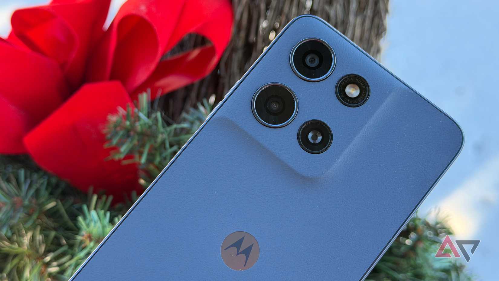 Moto G 2026 held up against a red bow