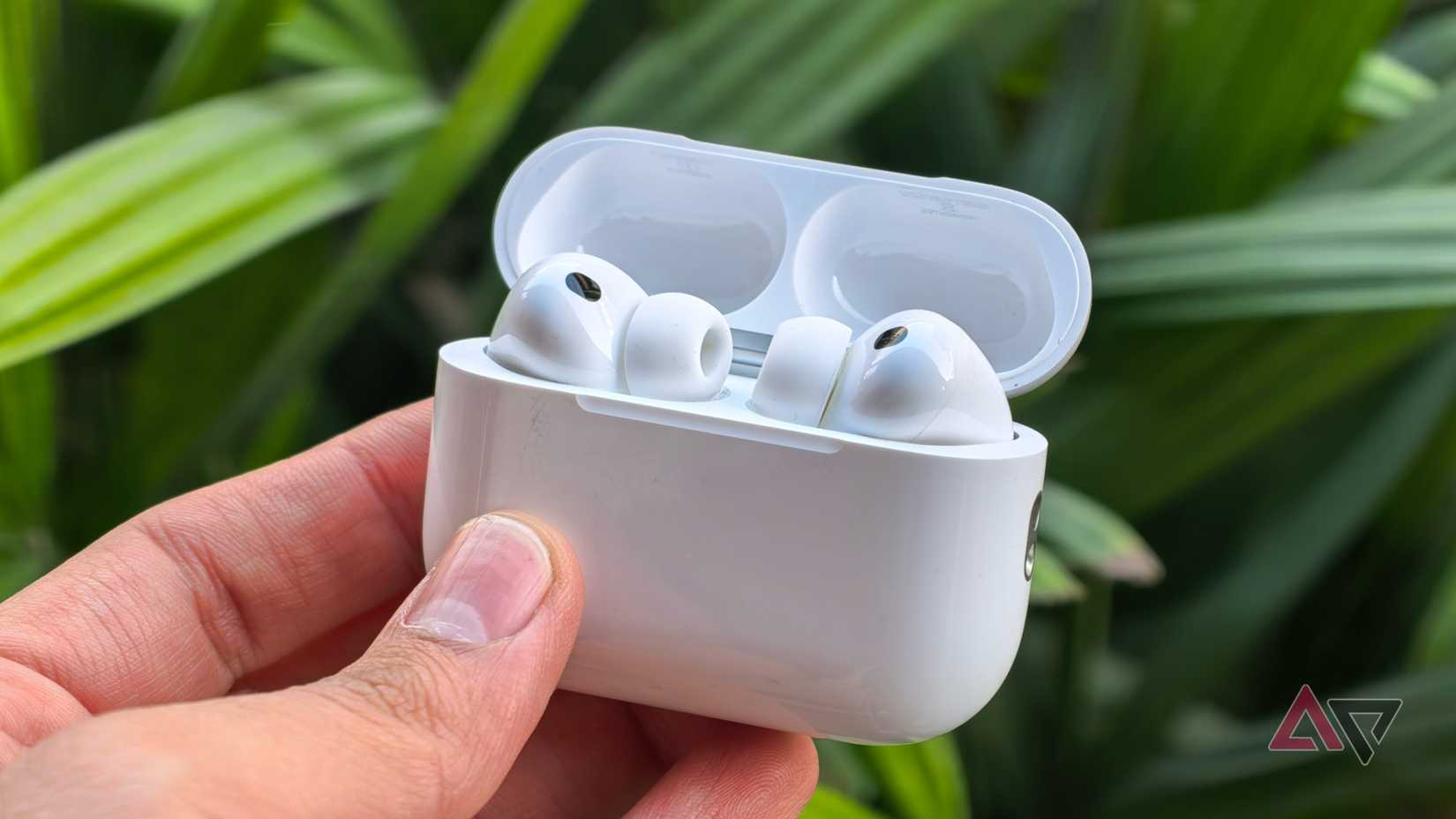 AirPods Pro 3 davanti a piante verdi