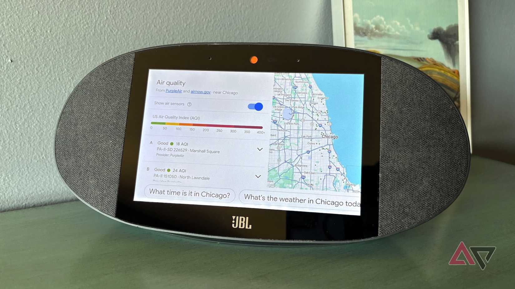 Um alto-falante JBL Google-Home exibindo as leituras do índice de qualidade do ar próximo a um mapa de Chicago.