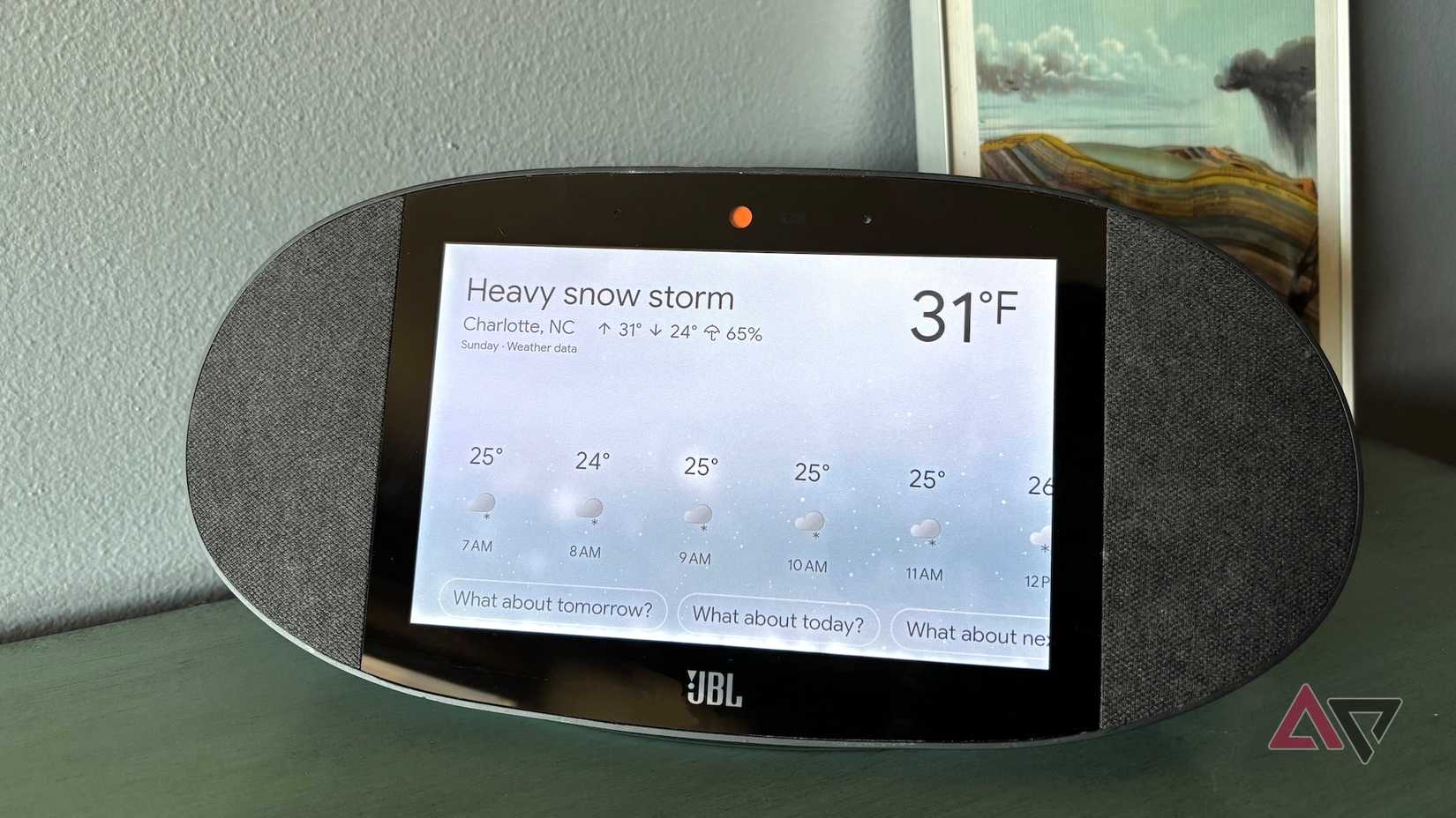 Um alto-falante JBL do Google Home exibindo a previsão de forte tempestade de neve para Charlotte, NC, por meio do Google Weather.