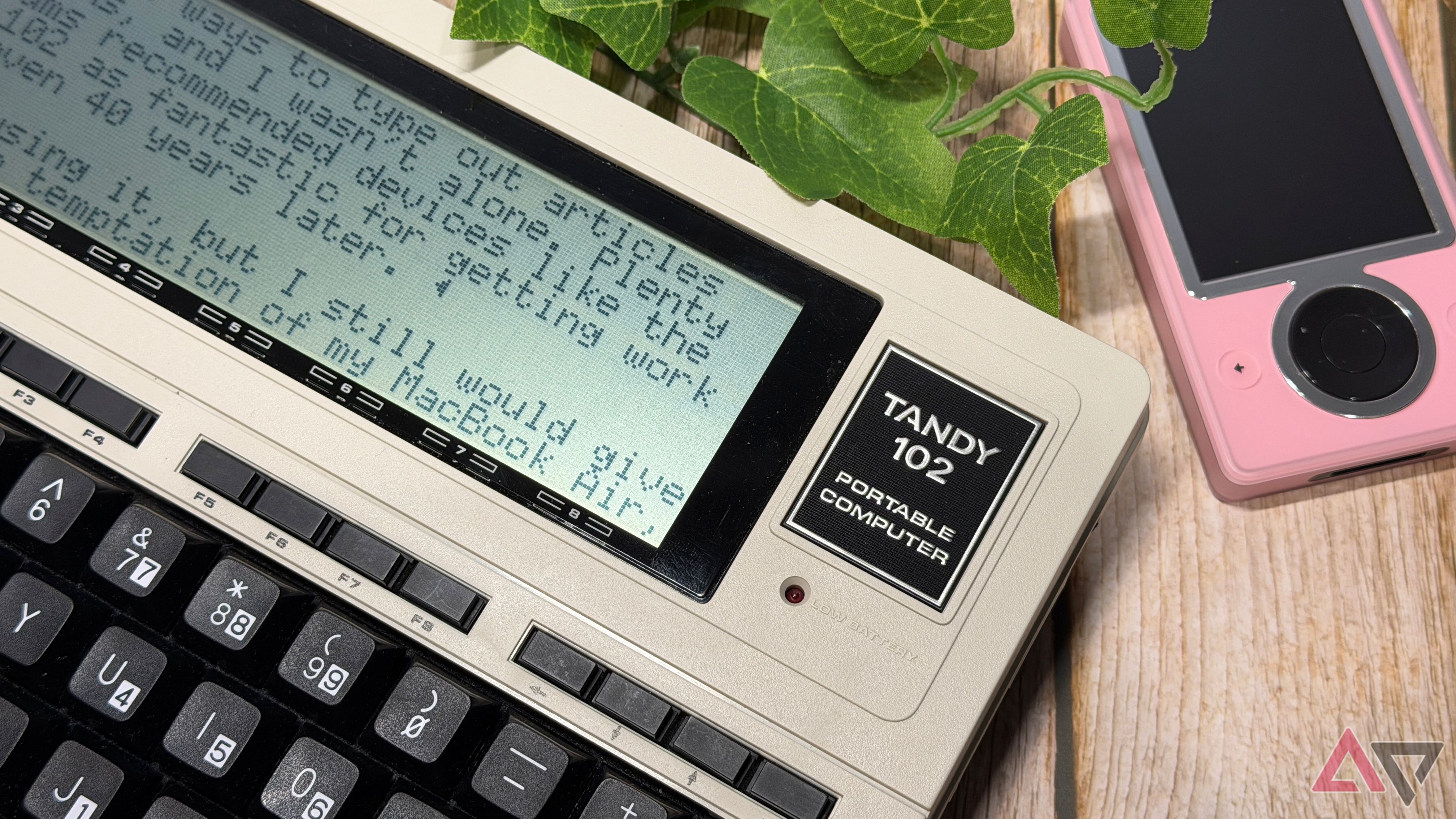 Tandy 102 laptop resting against a Microsoft Zune