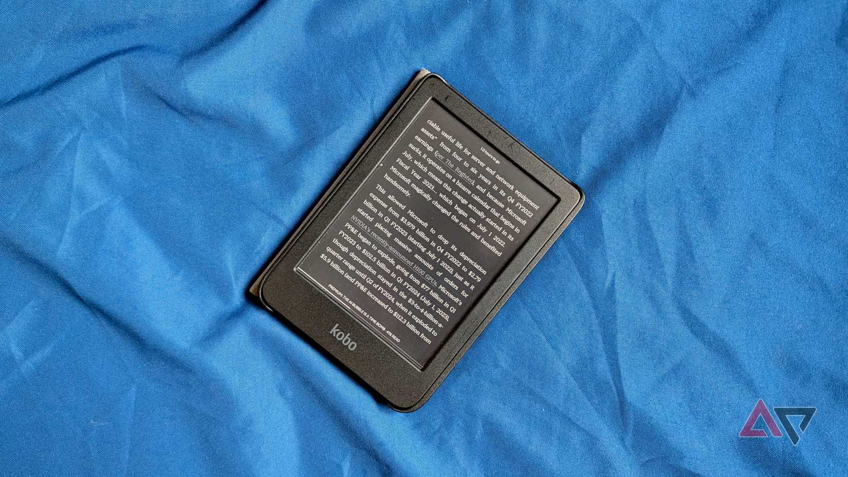 O Kobo Clara Color em uma cama.