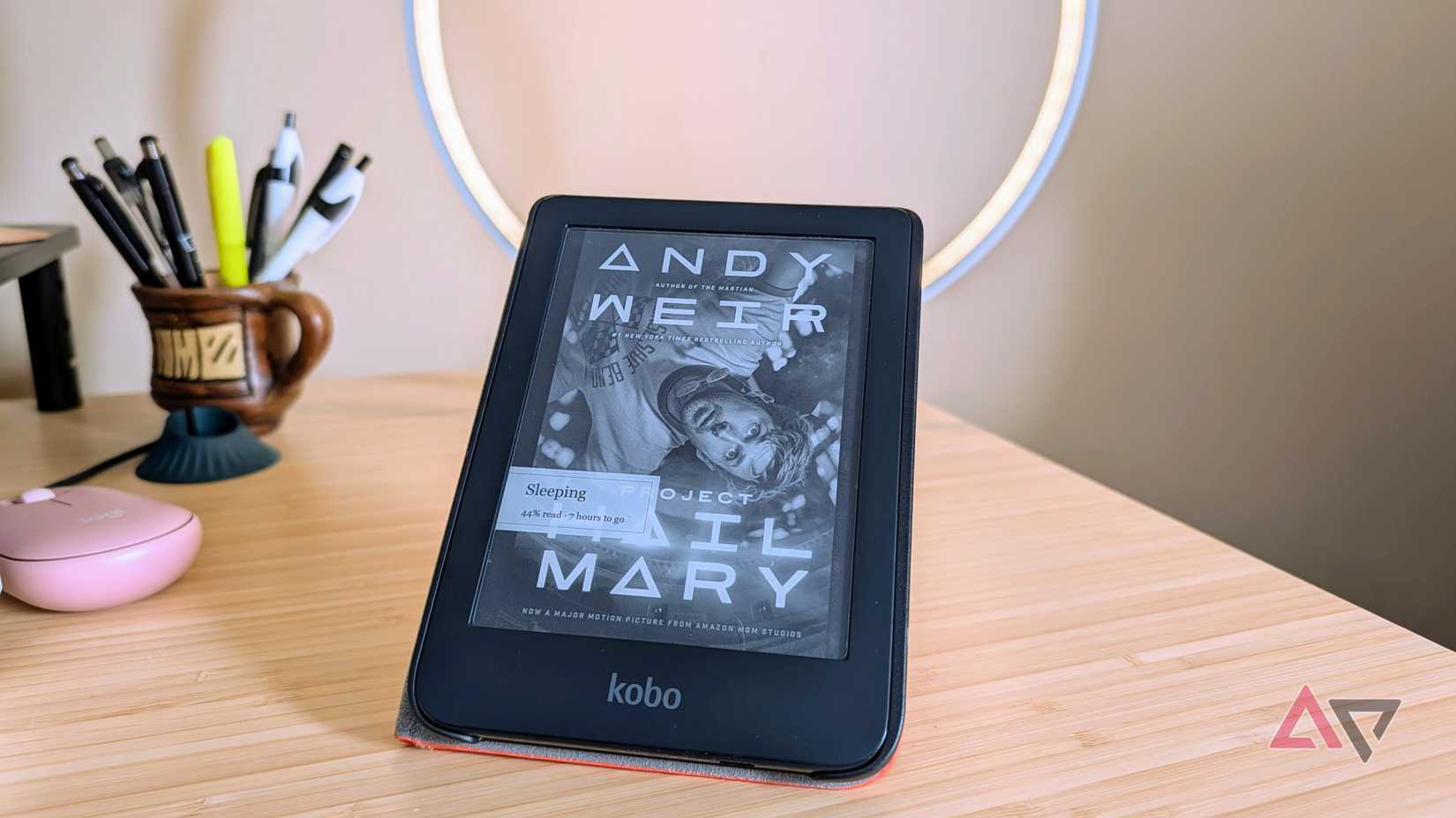 Um Kobo Clara 2E em cima de uma mesa, coberto com uma capa de dormir, exibindo o Projeto Hail Mary, de Andy Weir
