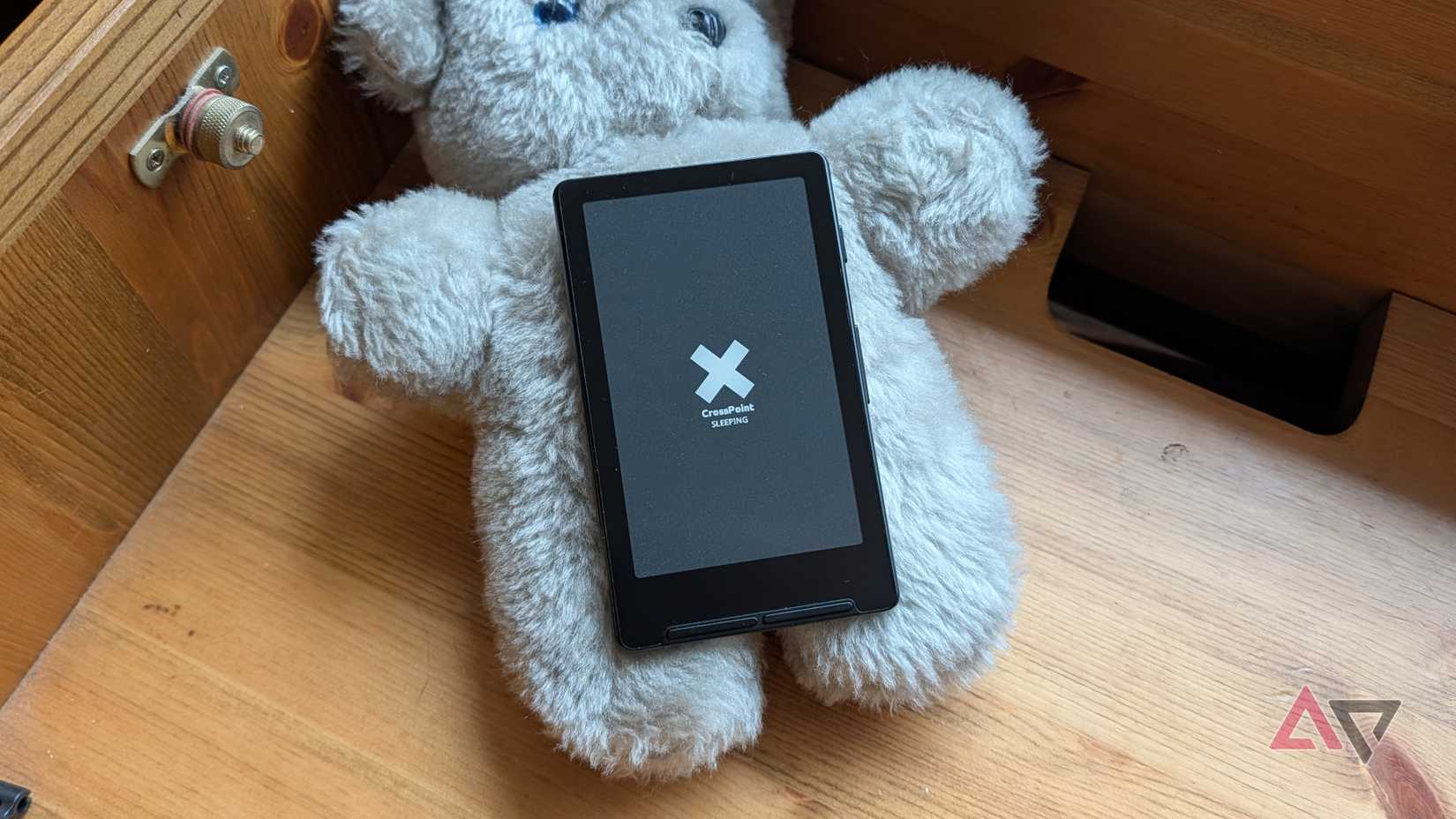 The Xteink X4 on top of a cupboard and a teddy bear.