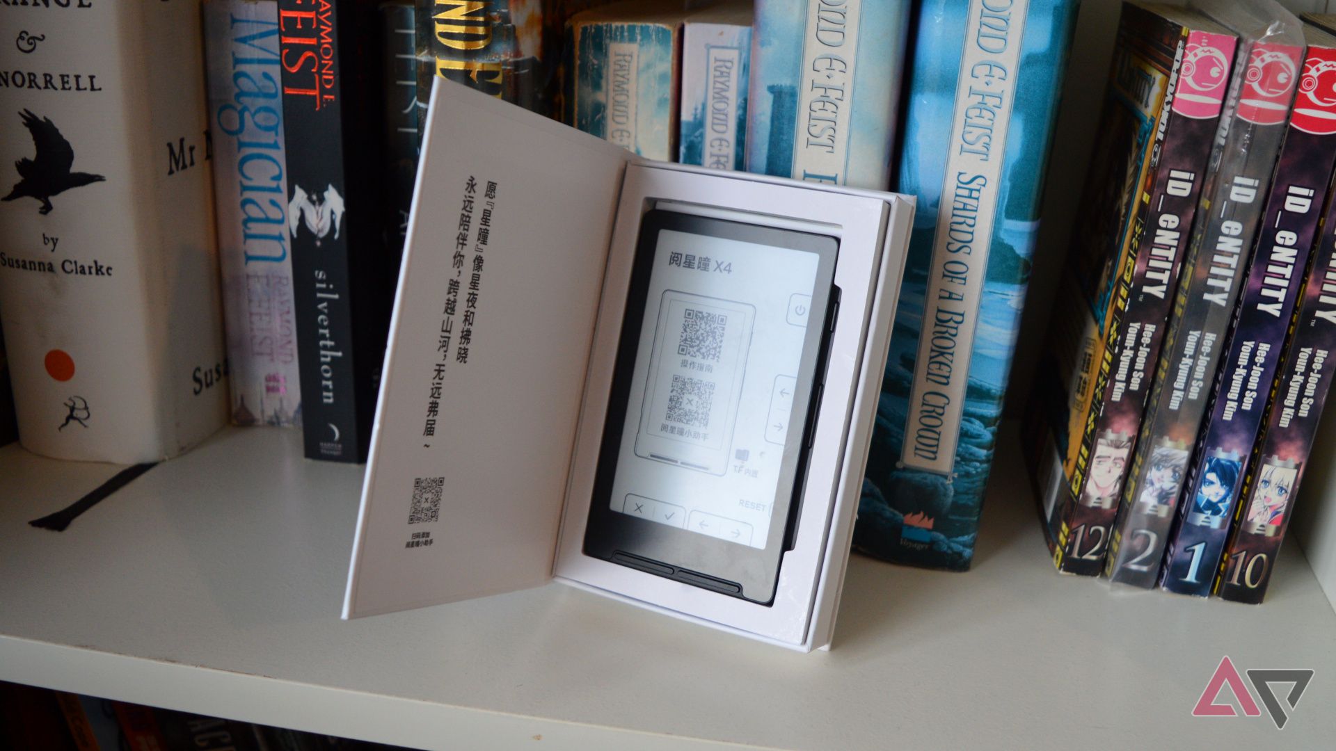 The Xteink X4 displayed in a box on a bookshelf.