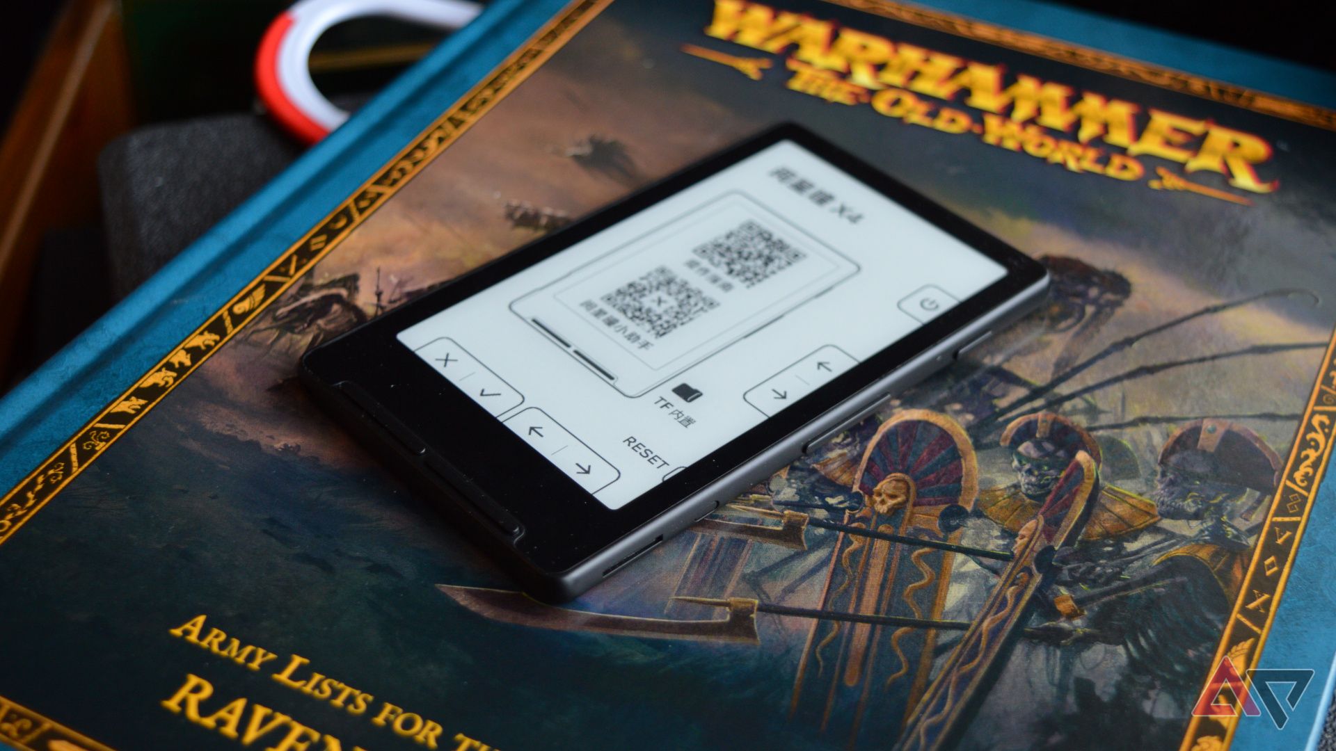 The Xteink X4 laid on a Warhammer book.