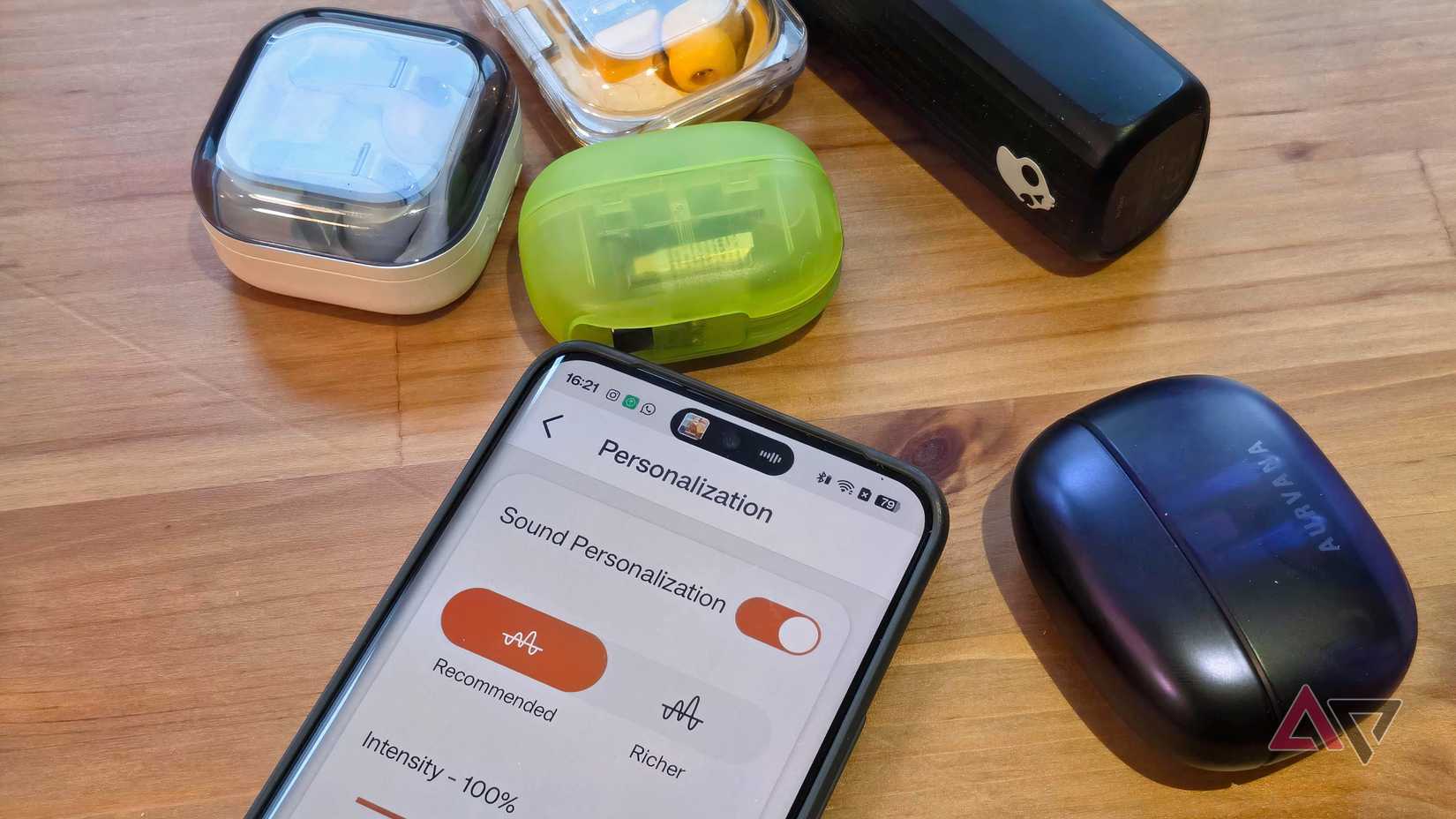 Um Realme 13 Pro com o teste de audição do aplicativo Creative e vários pares de fones de ouvido ao seu redor.