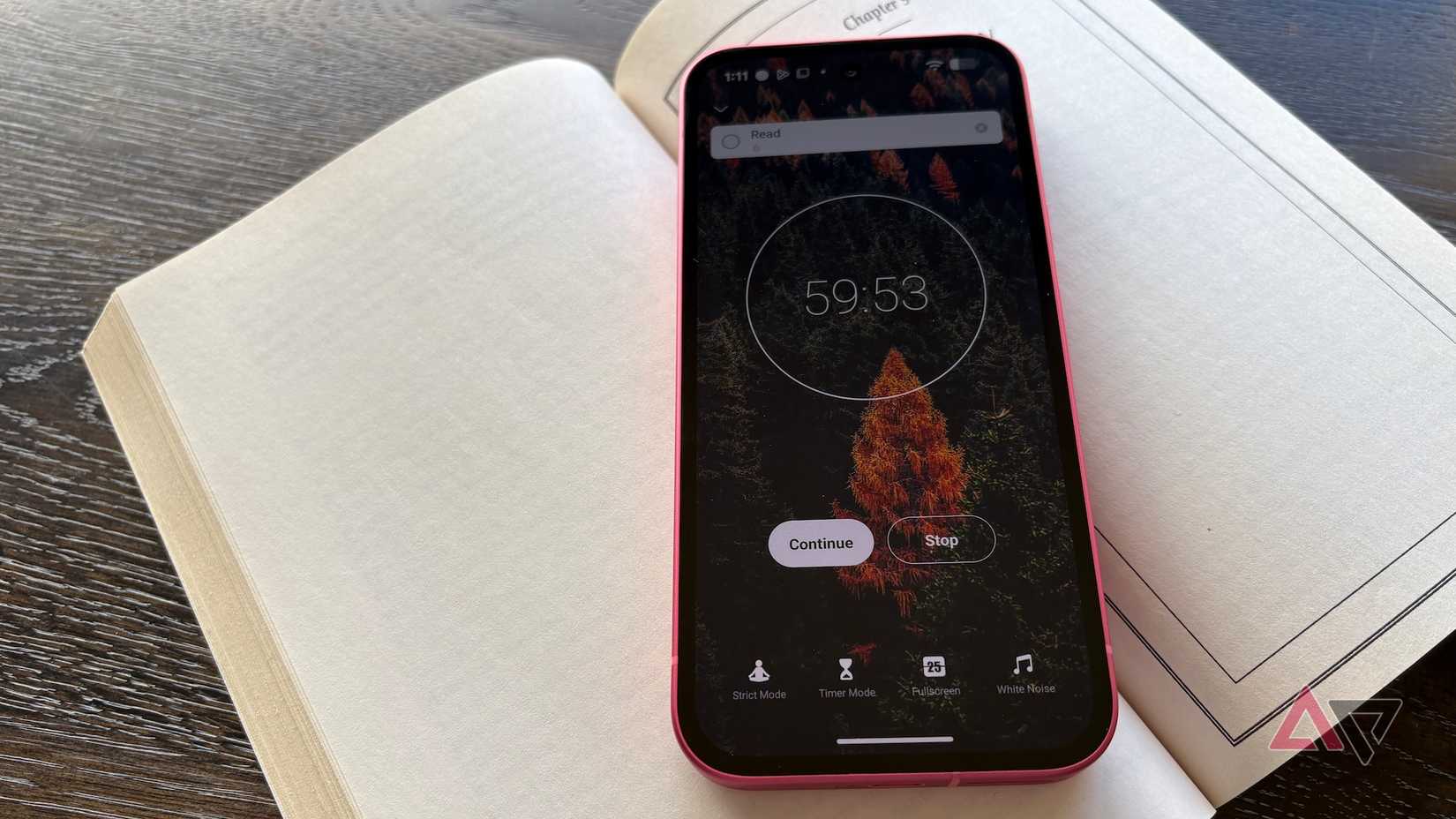 Un telefono con l'app Focus To-Do aperta con un timer 59:53 visualizzato con il telefono su un libro aperto