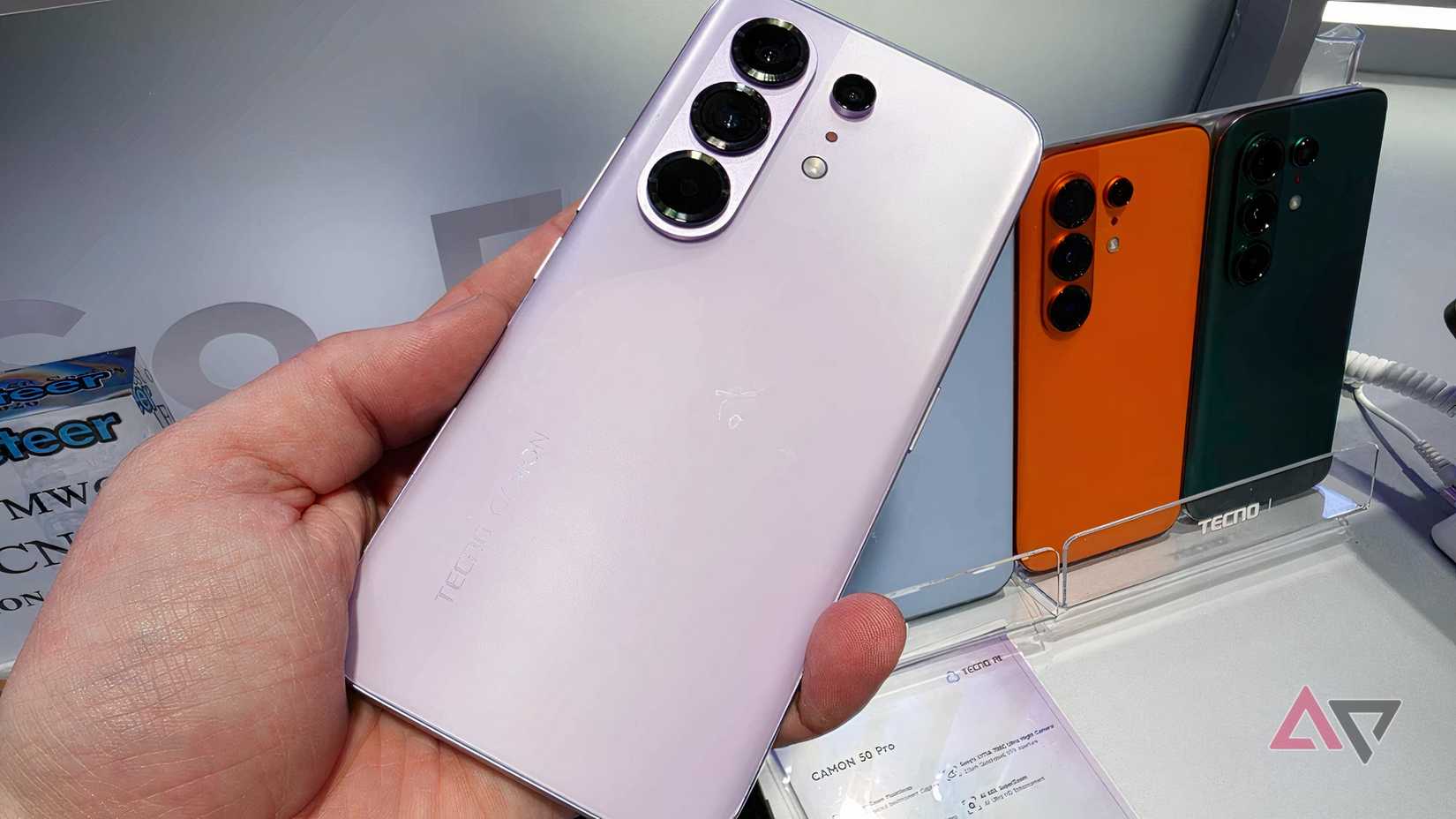 O Tecno Camon 50 Pro na mão de um homem, na frente de vários outros modelos do telefone.