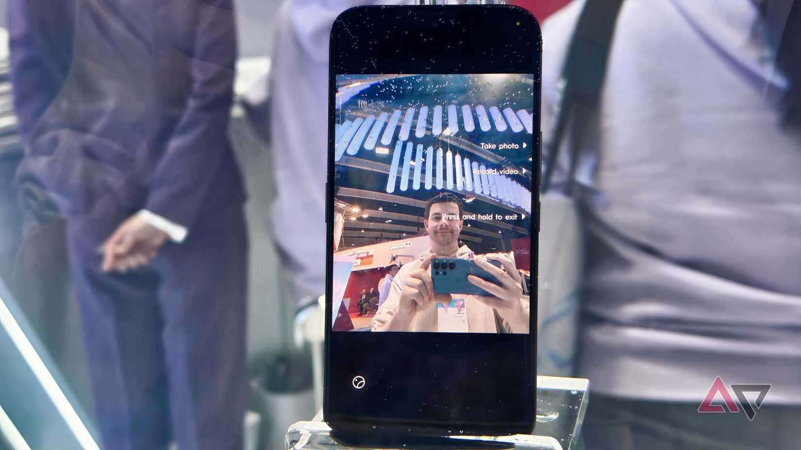 O Tecno Camon 50 em tanque de vidro, mostrando a prévia da câmera com um homem tirando foto.