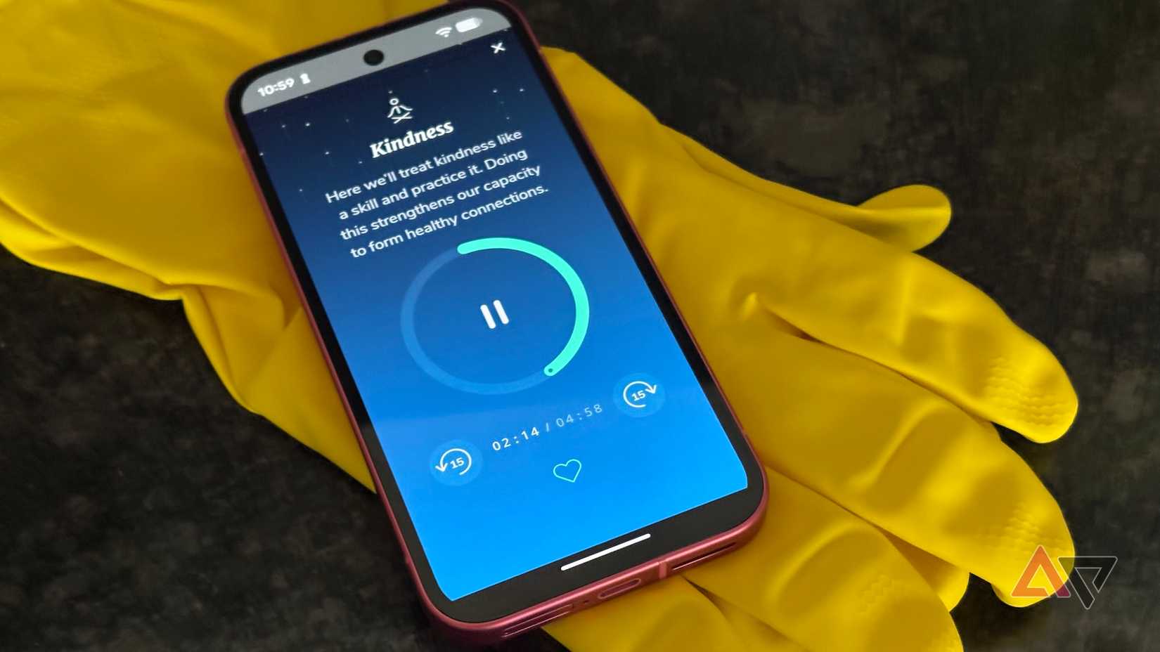 Um telefone exibindo o aplicativo de meditação Healthy Minds apoiado em um par de luvas de borracha amarelas