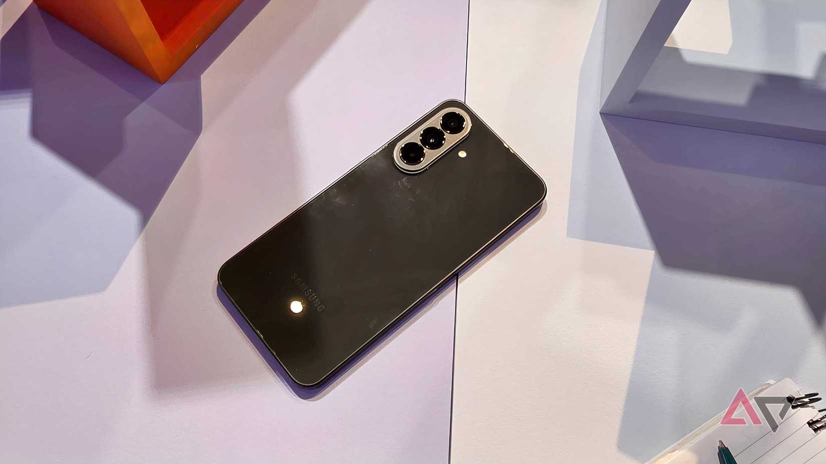 O Samsung Galaxy A37 cinza deitado sobre uma mesa.