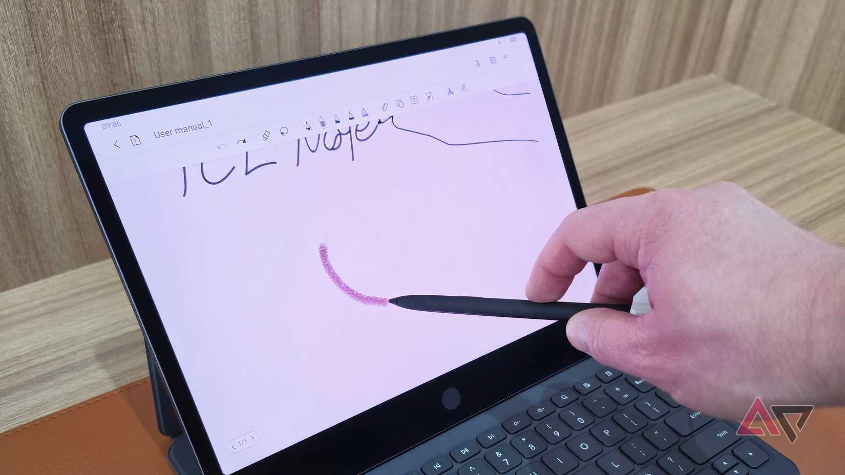 O TCL Tab A1 NXTPAPER em um fólio de teclado sobre uma mesa de madeira.