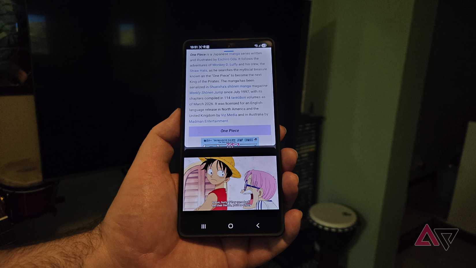 Um artigo sobre o anime One Piece e o show pode ser visto em um telefone na mão de alguém.