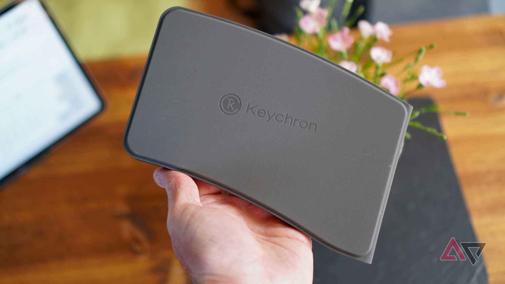 Uma pessoa segurando o Keychron B11 Pro fechado