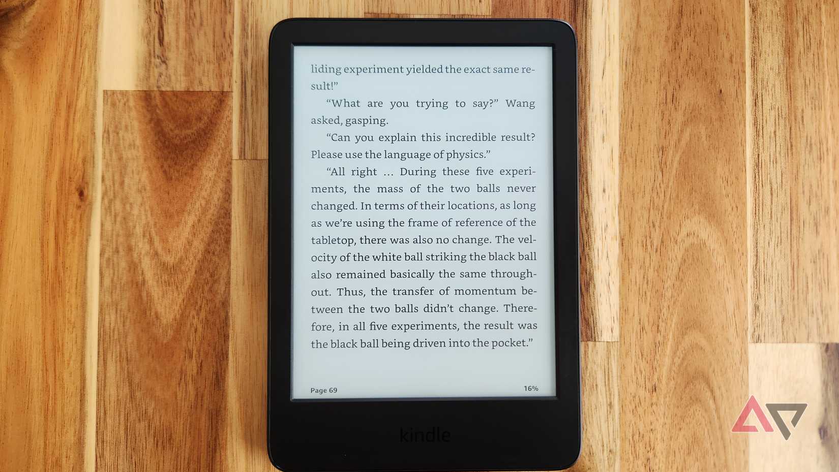Um Kindle está sobre uma mesa de madeira mostrando uma página de texto de um romance de ficção científica.