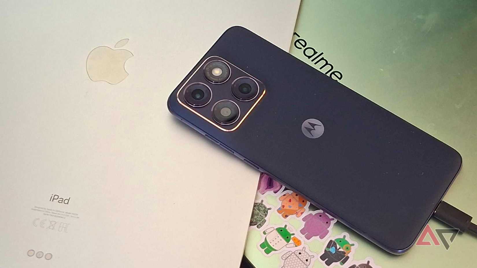 Um laptop Realme, um iPad e um telefone Motorola empilhados um em cima do outro.