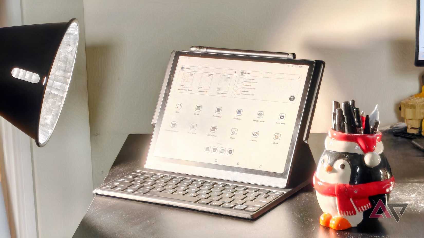 O Onyx Boox Tab Ultra C ao lado de um porta-caneta e luz de filme.
