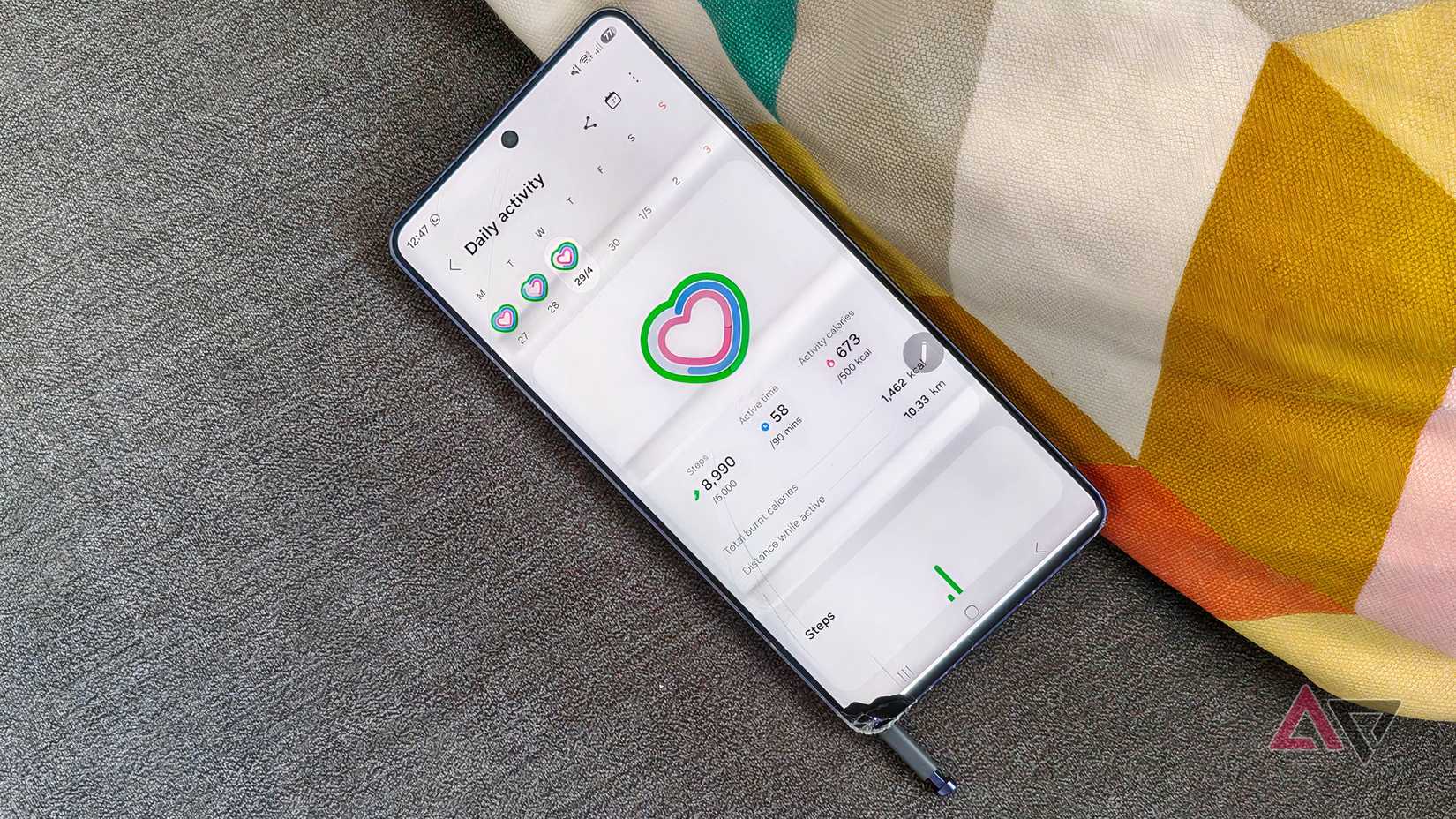 Um Samsung Galaxy S26 Ultra danificado com a página de atividades diárias exibida.