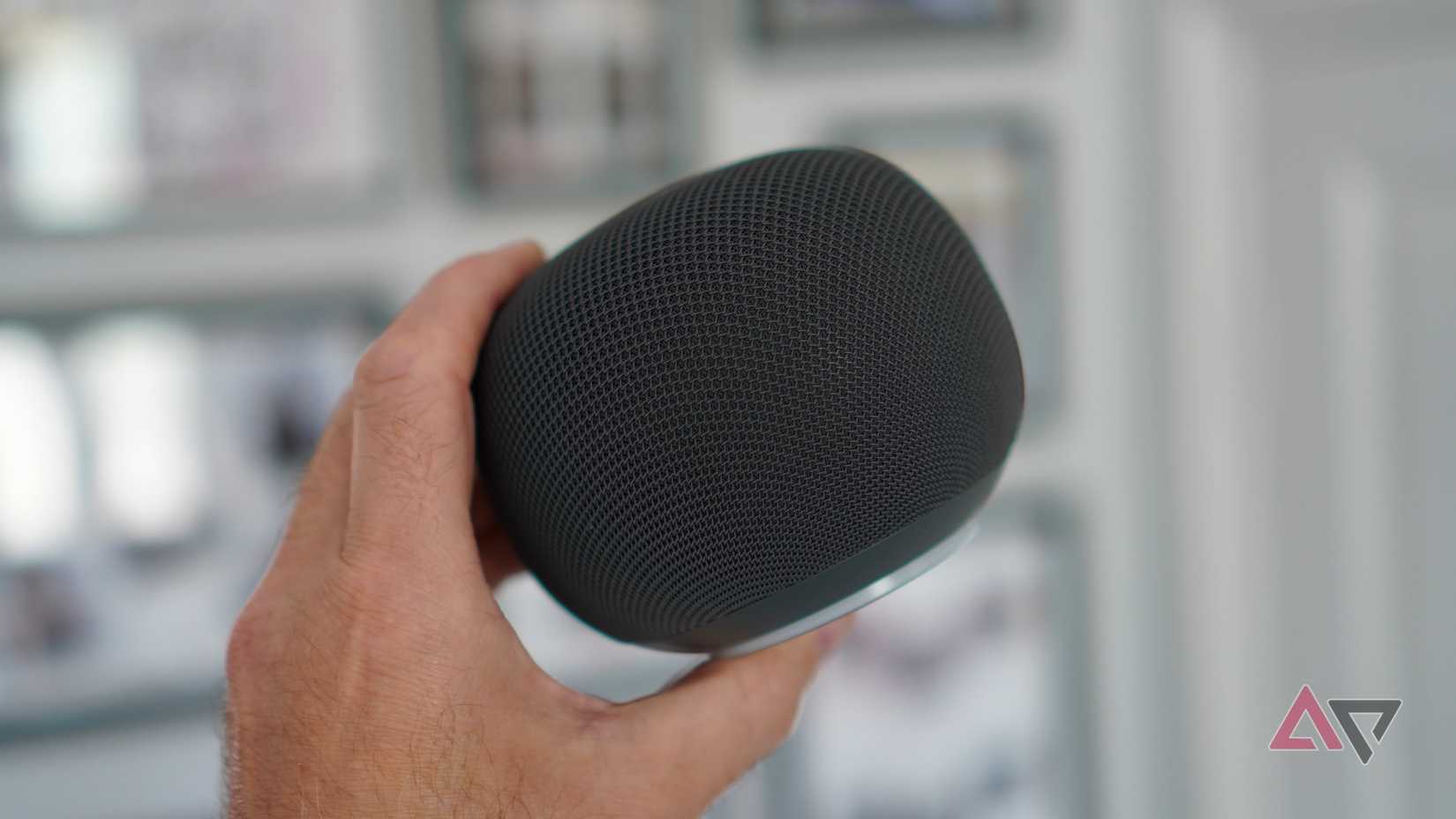 Uma pessoa segurando o alto-falante Google Home