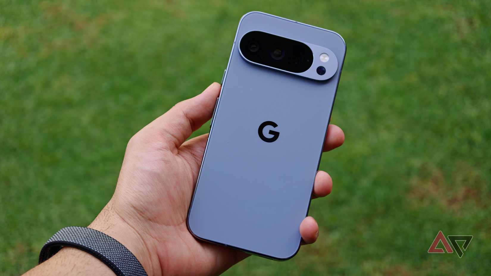 Um Google Pixel 10 Pro colorido Moonstone na mão em frente a uma grama verde