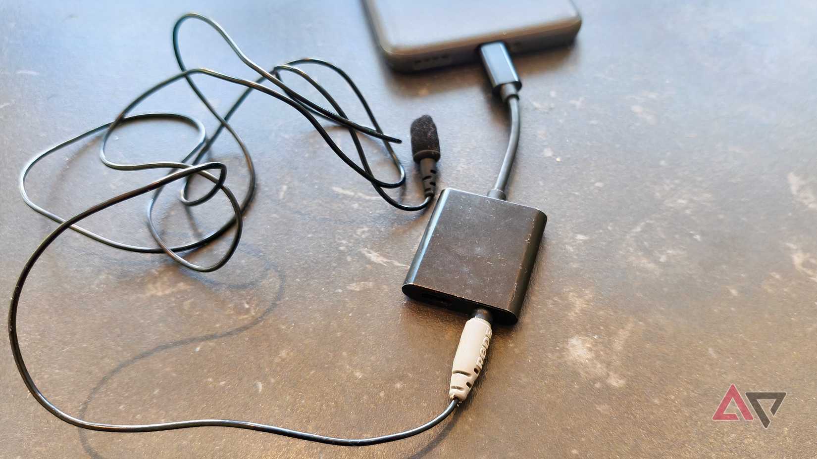 Um divisor USB-C/3,5 mm conectado a um microfone e um telefone Android.