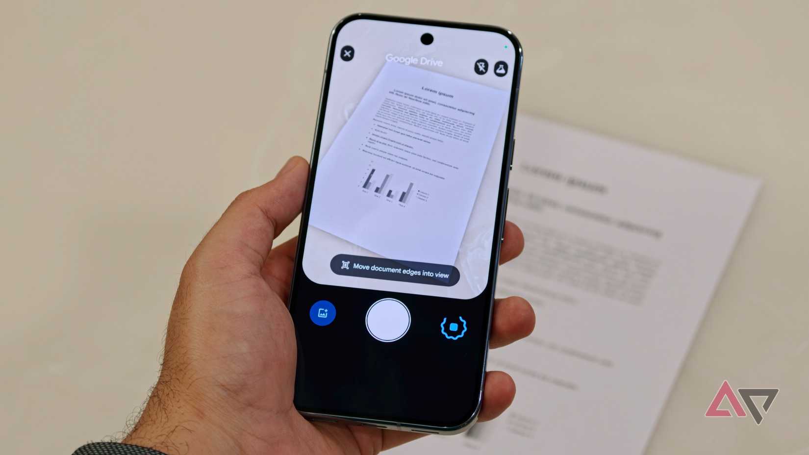 Uma pessoa segurando um smartphone usando o recurso integrado de digitalização de documentos do Google Drive para capturar uma página de texto contendo um gráfico de barras