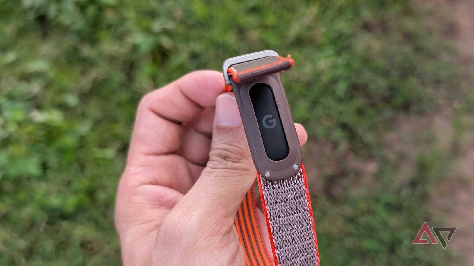 Google-Fitbit-Air-black-puck-with-Stephen-Curry-band-being-held-by-a-hand-showing-G-logo