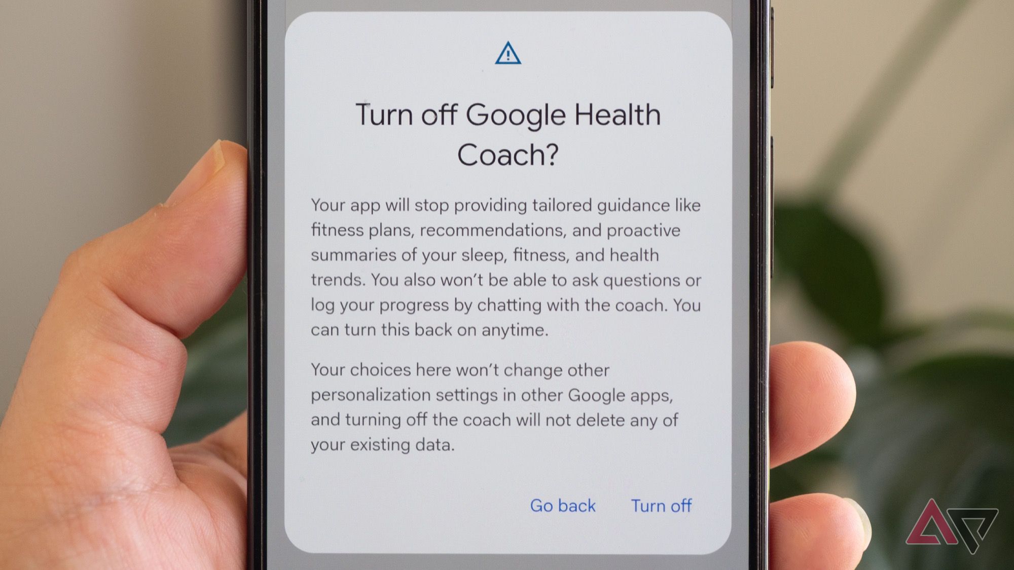 Pixel phone in hand showing the pop-up to turn off Google Health Coach