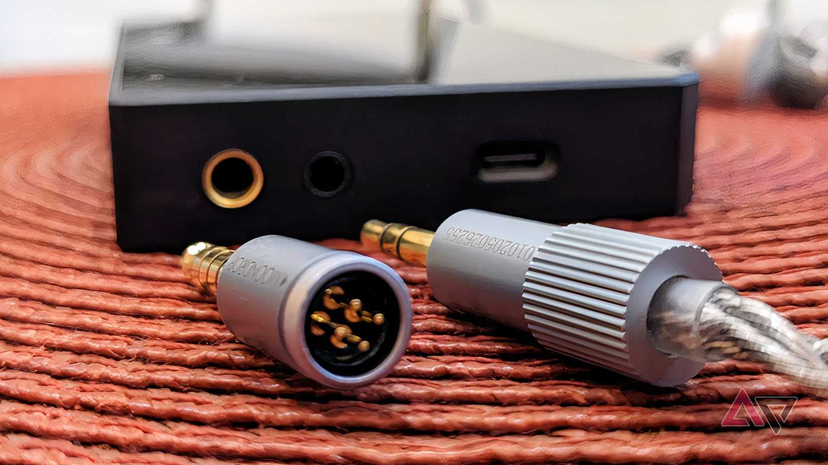 HiBy R4 next to earphones with 3.5mm and 4.4mm connectors
