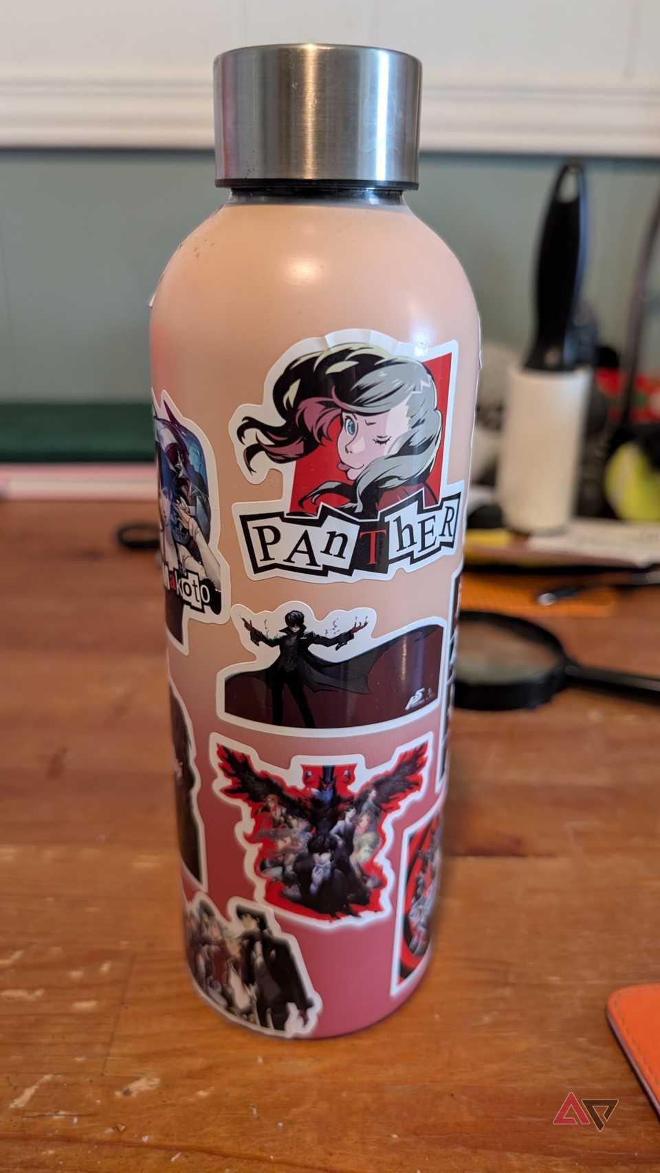 a bottle with stickers on a wooden table shot from a Pixel 8