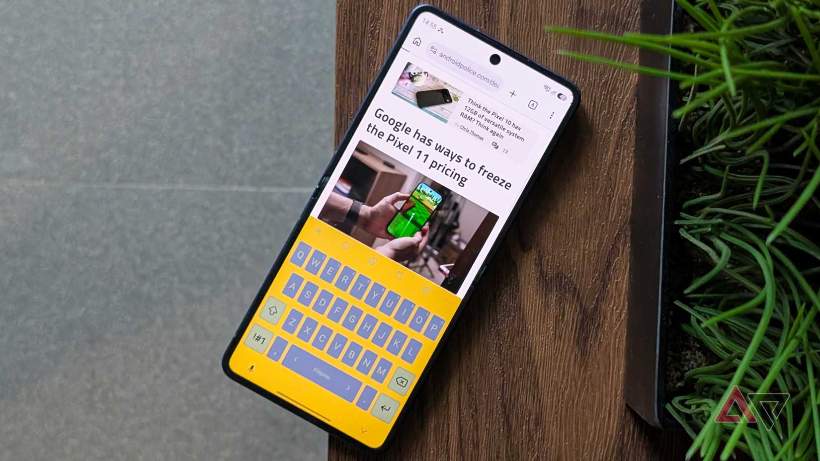 Samsung Galaxy Z Flip 7 smartphone unfolded with the Keyboard app in yellow theme on Android Police website