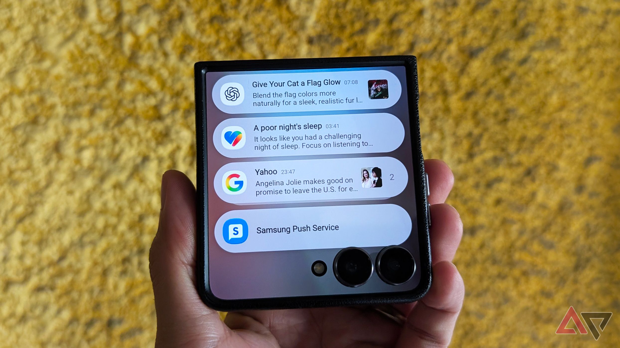 A hand holding a folded Samsung Galaxy Z Flip 7 with several app notifications