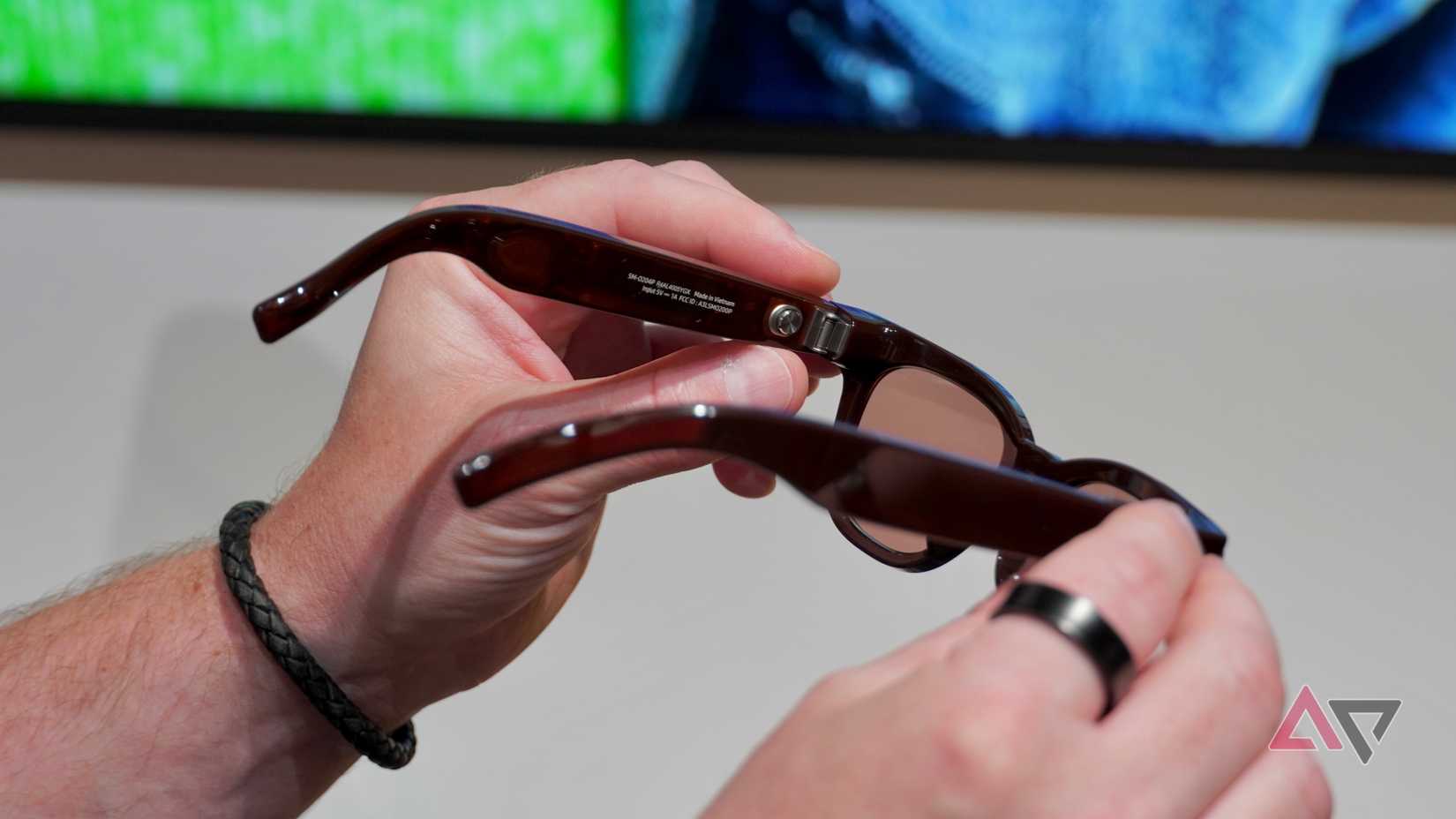 Uma pessoa segurando os óculos inteligentes Samsung x Warby Parker