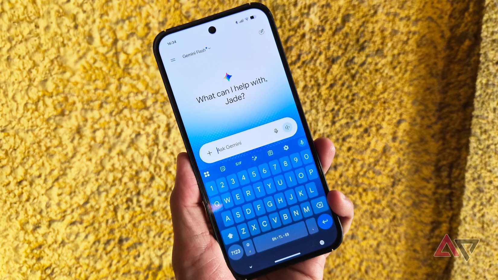 A hand holding a Google Pixel phone with Gemini app opened