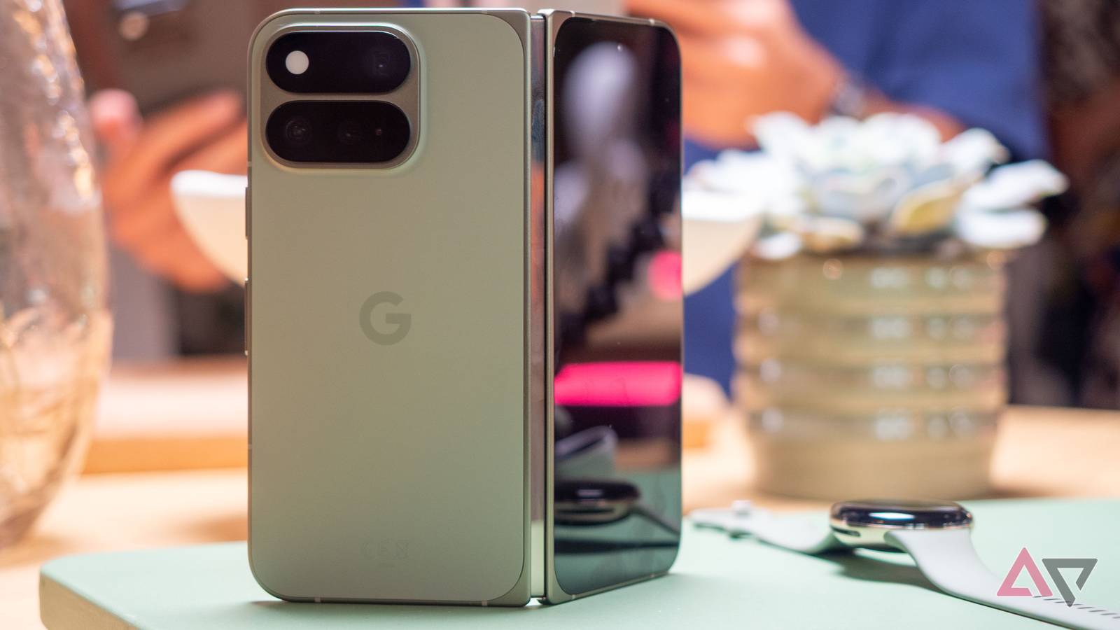 Google Pixel 11 Pro Fold in Olive color standing up, unfolded, seen from the back