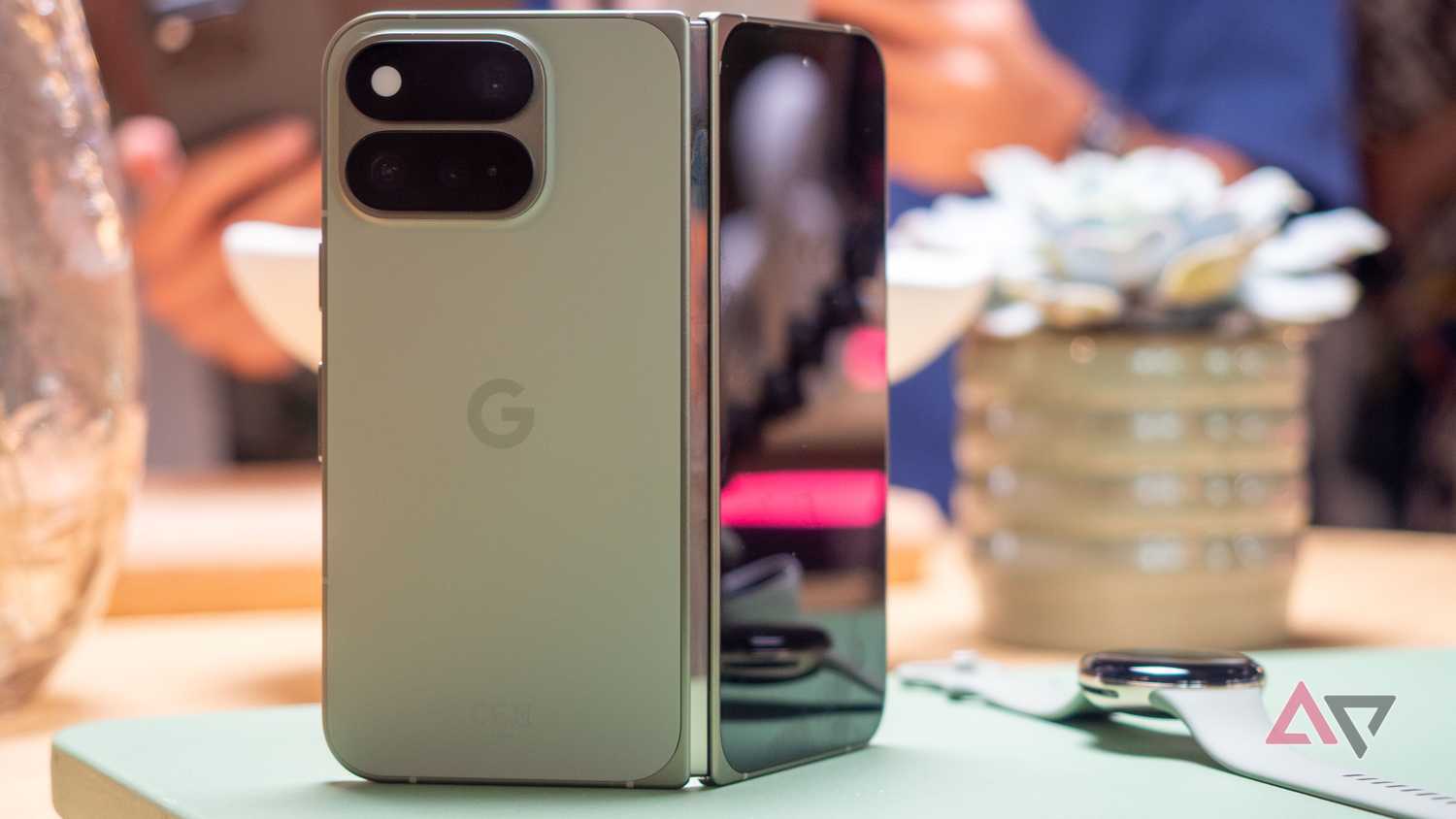 Google Pixel 11 Pro Fold in Olive color standing up, unfolded, seen from the back