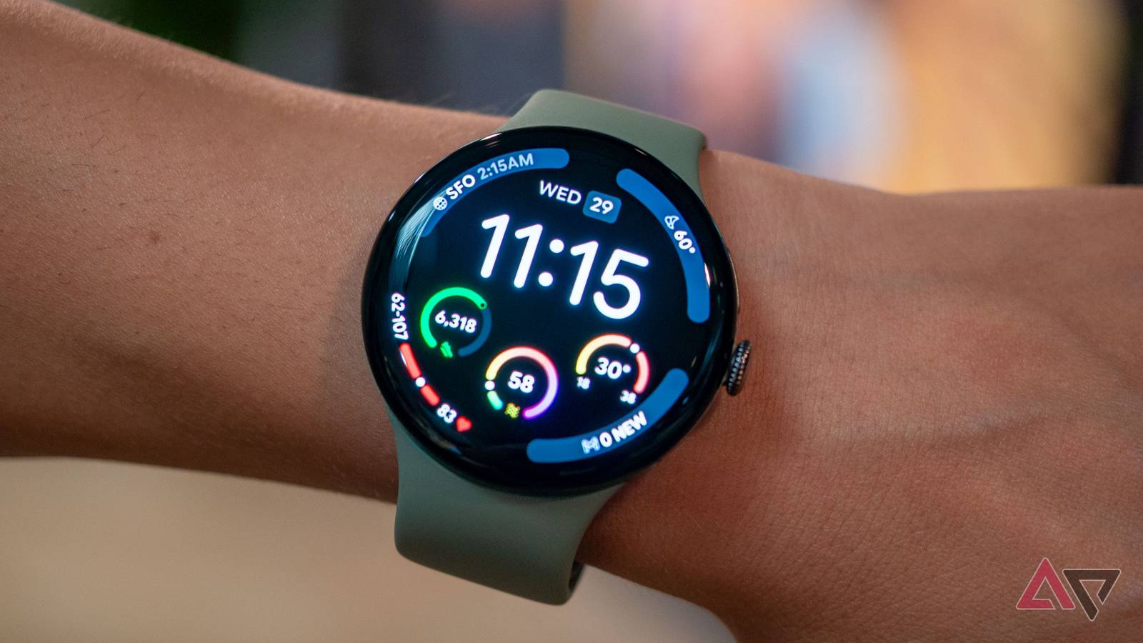 Google Pixel Watch 5 on wrist, showing colorful complications