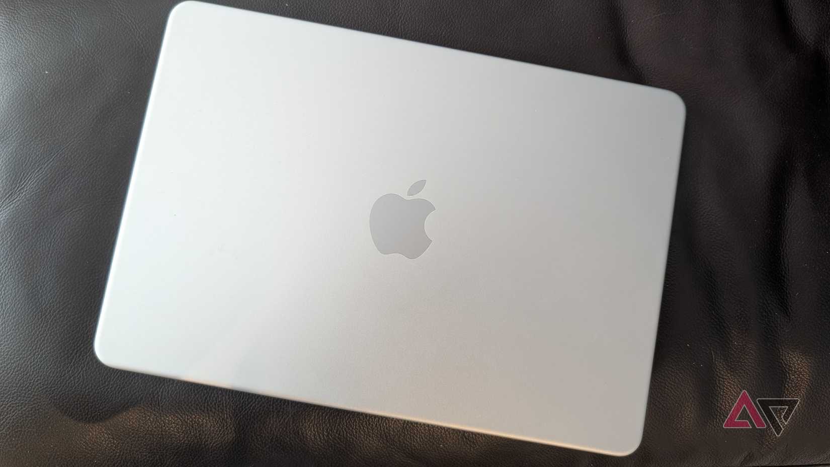 portatile Apple argentato su un divano in pelle nera
