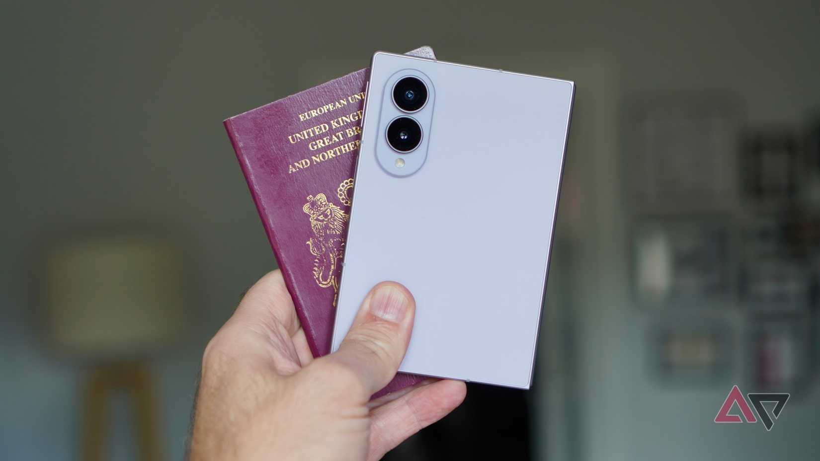 A person holding the Samsung Galaxy Z Fold 8 and a passport