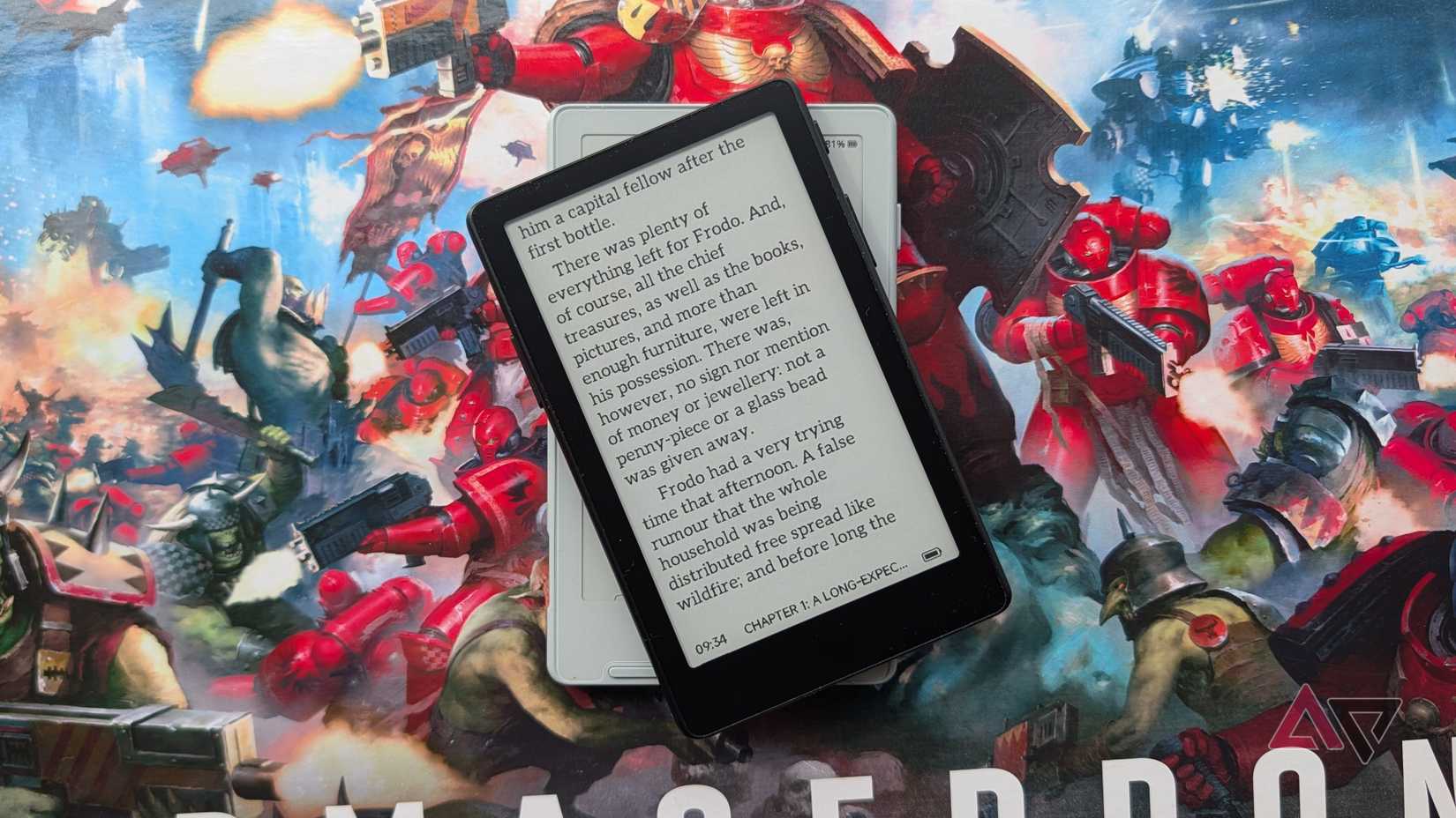 The Xteink X4 Pro laid over the X4, on top of a Warhammer box.