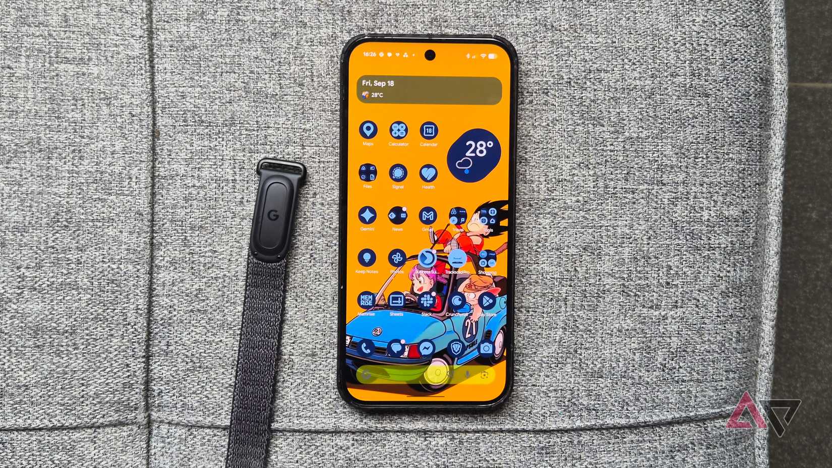 Google-Fitbit-Air-smart-tracker-and-Pixel-smartphone-with-a-bright-yellow-dragon-ball-wallpaper