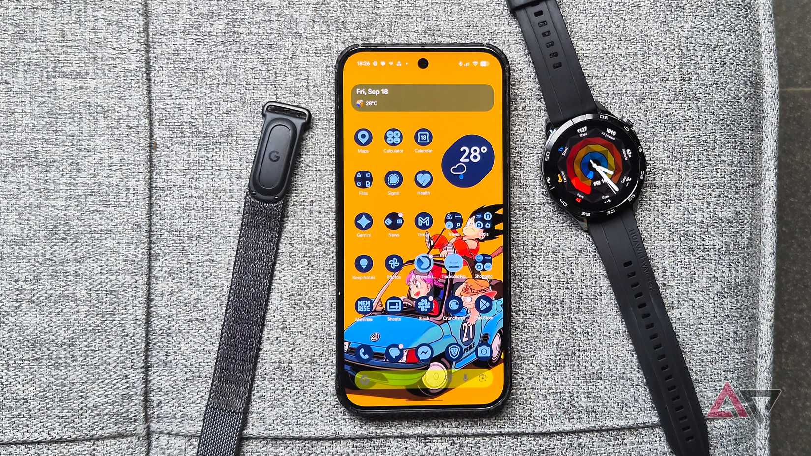 Google-Fitbit-Air-tracker-smart-band-Pixel-phone-and-Huawei-smartwatch-on-a-couch-showing-bright-wallpaper