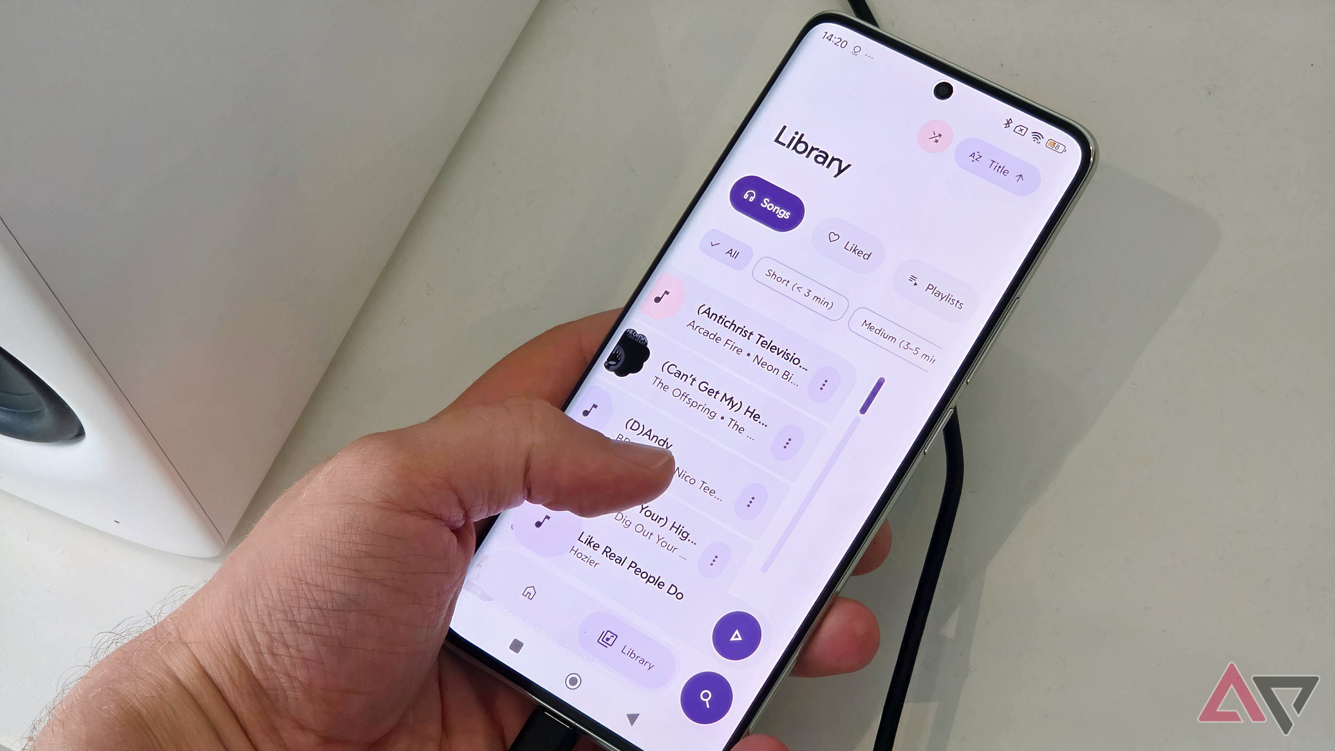 A Poco X7 plugged into an Edifier M90, showing the Rhythm app with a man scrolling through the Library page.