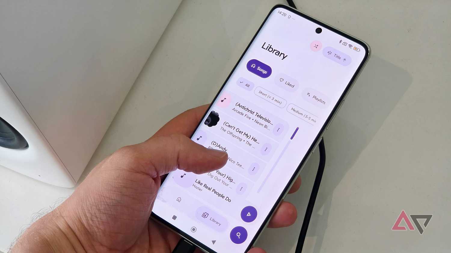 A Poco X7 plugged into an Edifier M90, showing the Rhythm app with a man scrolling through the Library page.