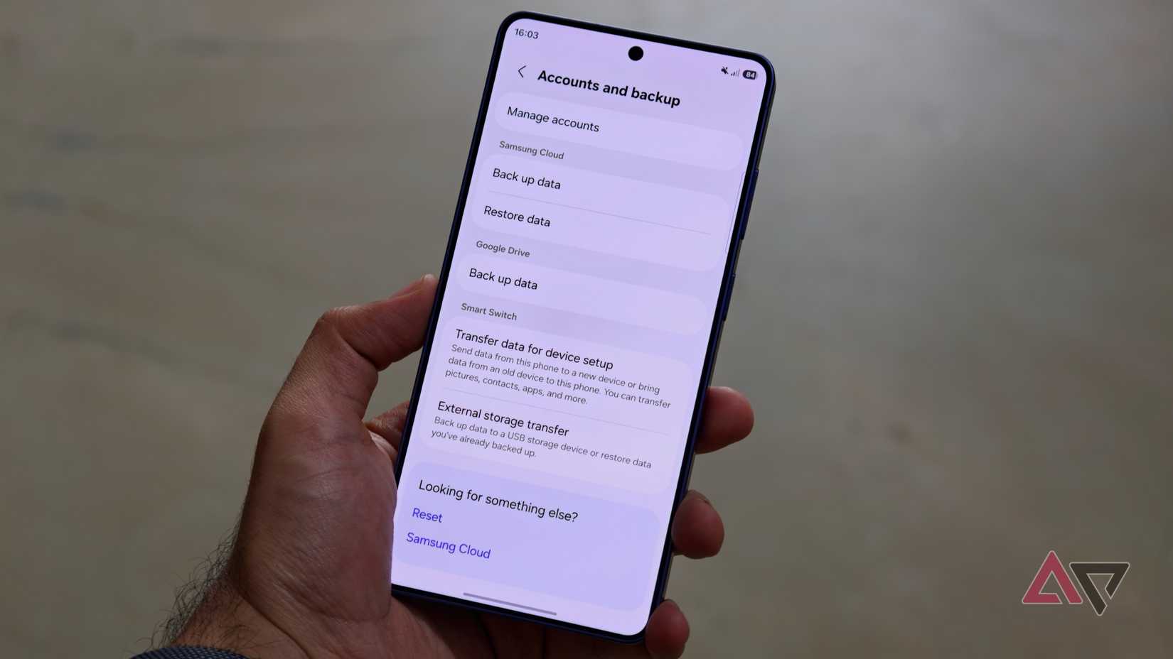 A person holding a Samsung Galaxy smartphone displaying the Accounts and backup settings menu